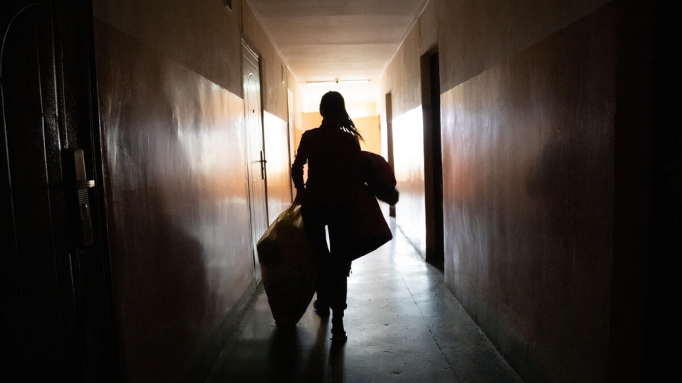 Oleksandra ramène des couvertures et des vêtements chauds dans la chambre qu'occupe sa famille dans la résidence universitaire de Mukachevo.