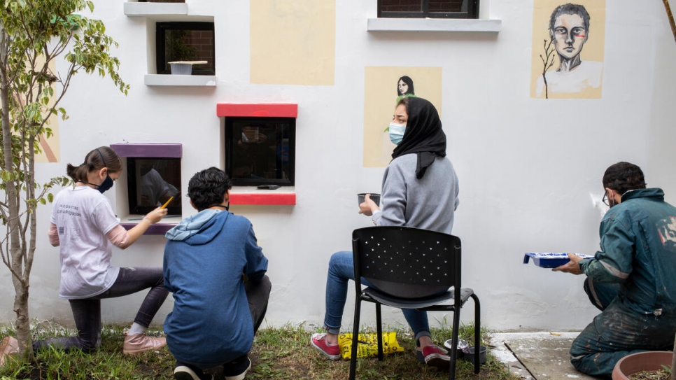 Les artistes au travail. Zohra et ses collègues peintres progressent sur la fresque du Centre pour l'égalité et la justice. 