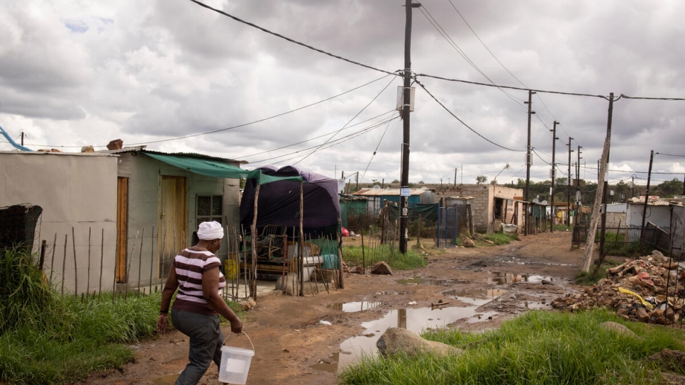 Bonisiwe recolecta agua de la llave comunitaria en la aldea Mamelodi, cerca de Pretoria, Sudáfrica.