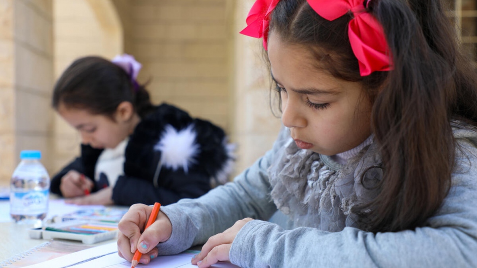 Mais, de 7 años, (a la izquierda) y Marah, de 9 años, (a la derecha) dibujan imágenes de Siria en un centro comunitario de Madaba, Jordania.