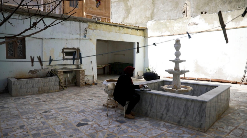 Jalila sirve té junto a la fuente de su patio rehabilitado.