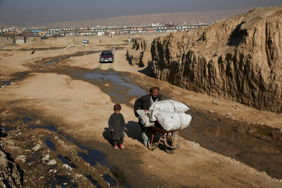 Mullah Ahmed y su hijo de cinco años llevan leña a su albergue temporal en Kabul. Por fortuna, logró adquirir combustible luego de recibir asistencia de ACNUR para sobrellevar el invierno.