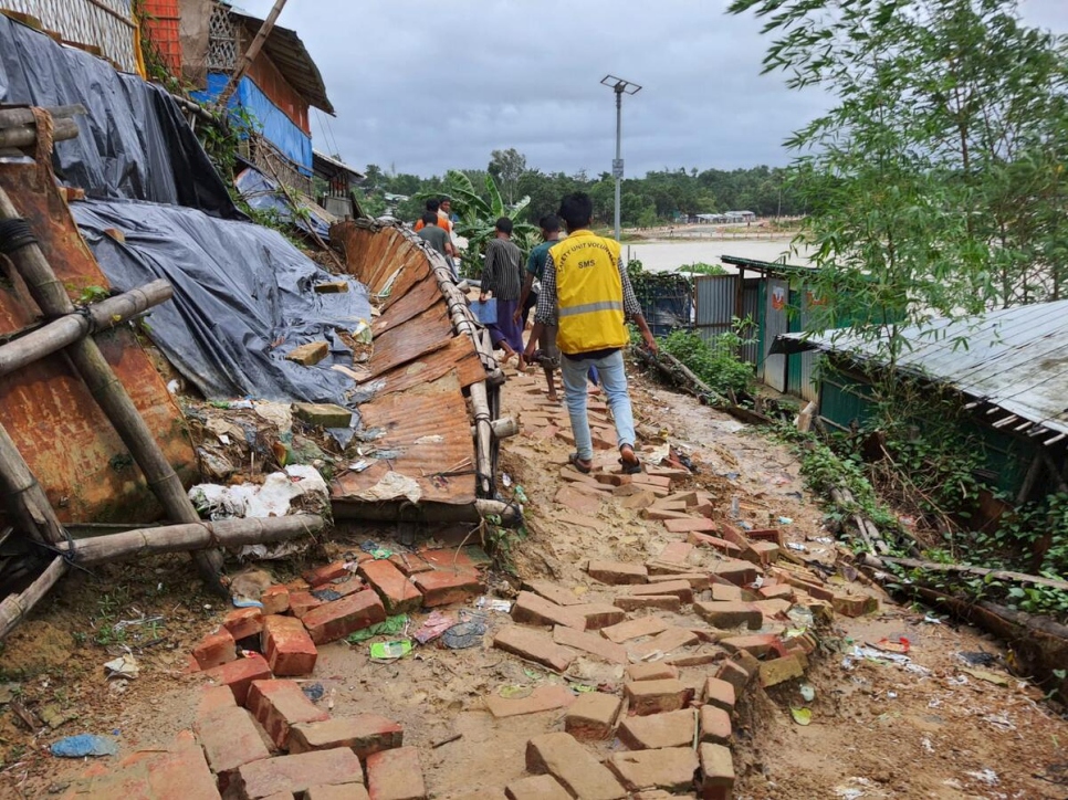 Personas refugiadas voluntarias trabajan día y noche bajo una intensa lluvia para rescatar a las personas refugiadas que se vieron afectadas por las graves inundaciones en los campamentos.