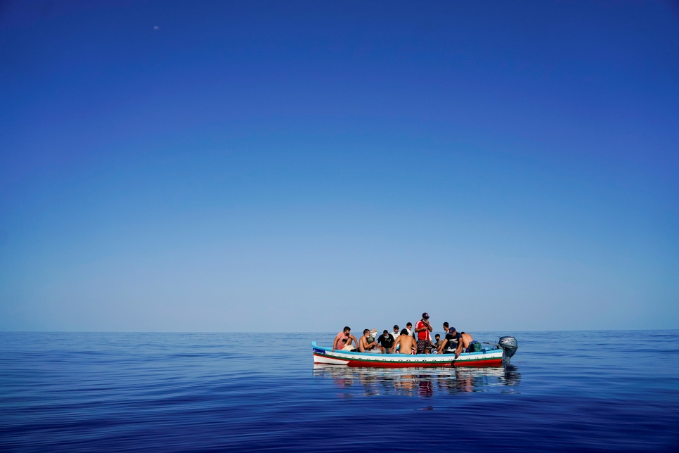 A la deriva, en una embarcación de madera, personas refugiadas y migrantes esperan ser rescatadas cerca de Lampedusa, una isla italiana en el mar Mediterráneo (28 de agosto de 2021).