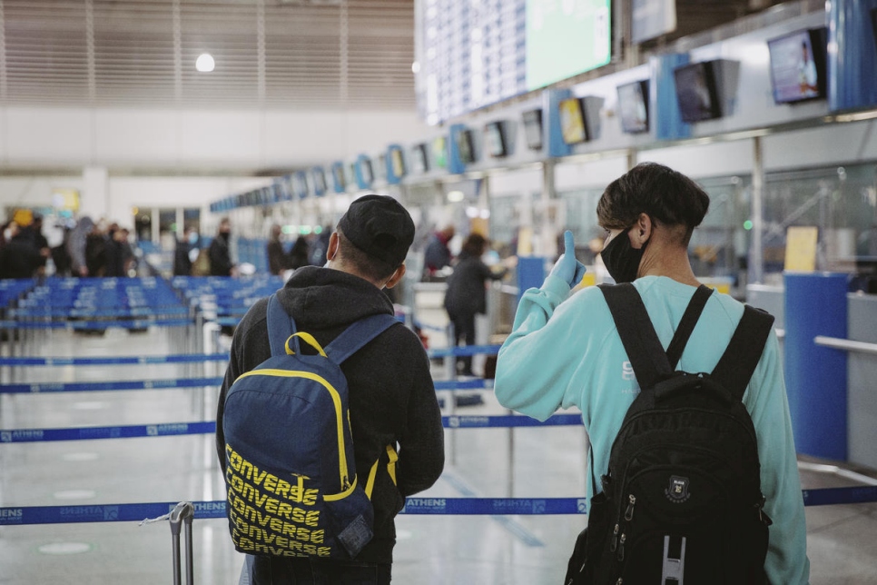 Dos niños refugiados afganos no acompañados se preparan para abordar un vuelo de reubicación a Francia en el aeropuerto internacional de Atenas.