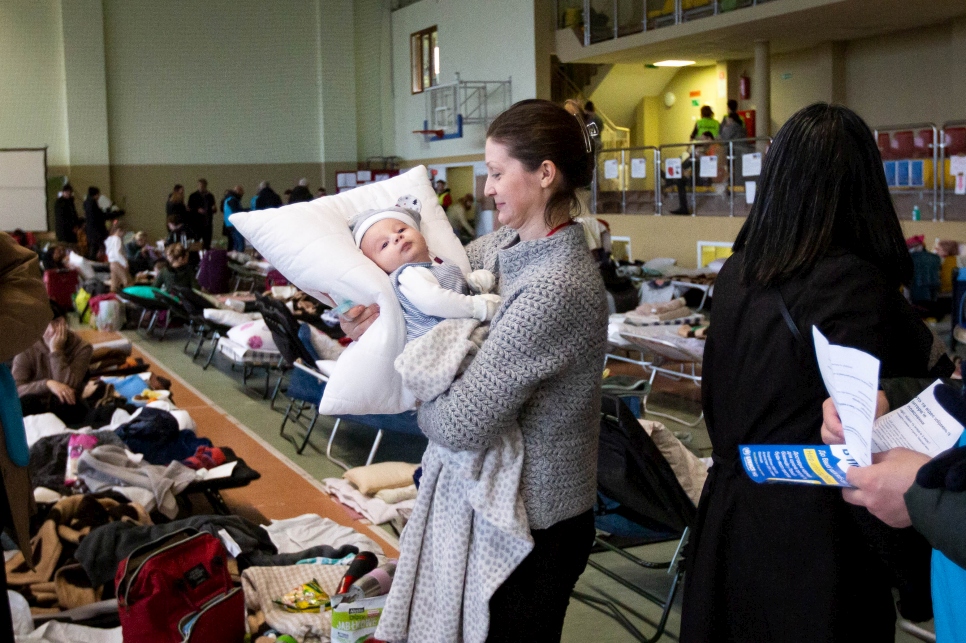 Valentina, de Kharkiv (noreste de Ucrania), carga a su sobrino Andrii en un centro de recepción en la ciudad fronteriza polaca de Medyka.