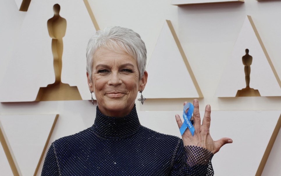 En apoyo a las personas refugiadas del mundo, Jamie Lee Curtis sostiene un lazo en el que se lee "With Refugees" (Con los refugiados) en la alfombra roja de la edición 94 de los Oscares en Los Ángeles, 27 de marzo de 2022.