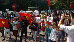 Protesters hold up a Vietnamese flag (L) while others shout slogans against Beijing over the South China Sea dispute in Hanoi on August 5, 2012.