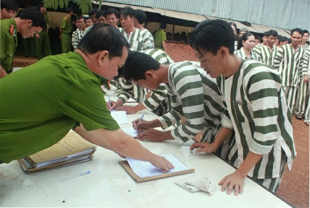 Inmates from Binh Phuoc province sign papers as they are freed under a prisoner amnesty, Aug. 30, 2011. 