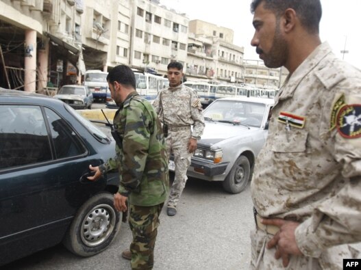 Disarmed members of the Sahwa militia that helped oppose Al-Qaeda influence man a checkpoint in Baghdad in April 2009.