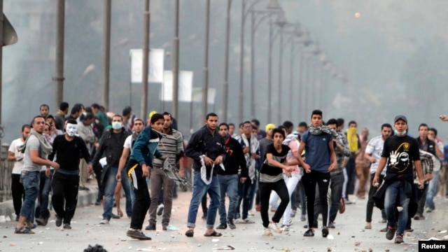 Supporters of ousted Egyptian President Muhammad Morsi throw stones at riot police during clashes in Cairo on November 22.