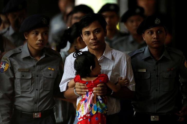 Detained and handcuffed Reuters journalist Kyaw Soe Oo carries his daughter Moe Thin Wai Zin while arriving for a court hearing in Yangon, Myanmar on May 2, 2018.