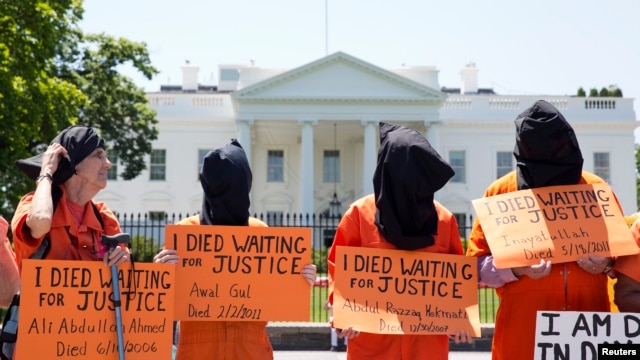 Activists wearing orange jumpsuits mark the 100th day of a prisoners' hunger strike at Guantanamo Bay during a protest in May in front of the White House in Washington, D.C.