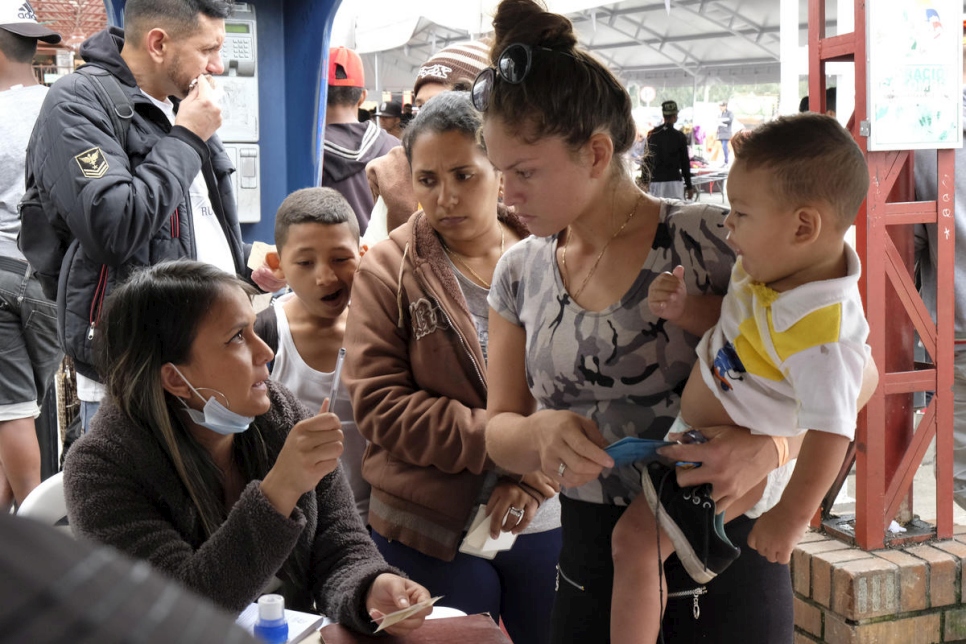 Mujeres y niños se encuentran entre los Venezolanos que cruzan el puente internacional de Rumichaca, el principal punto de ingreso a Ecuador desde Colombia, noviembre de 2018. 