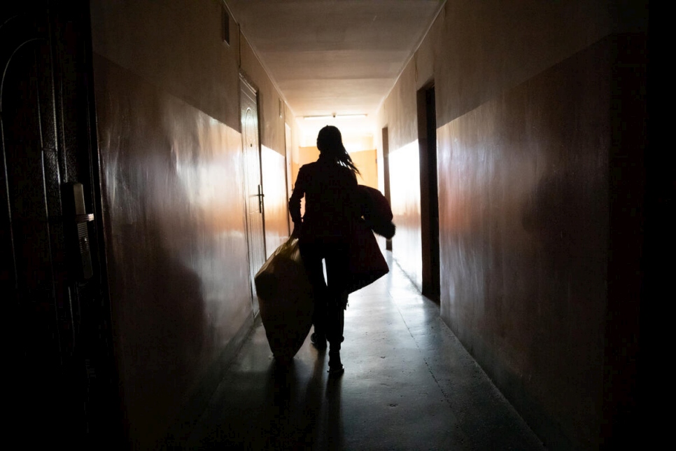 Oleksandra, que tuvo que huir de su casa en el este de Ucrania, lleva mantas y ropa de abrigo a la habitación donde está viviendo con su familia en la residencia universitaria de Mukachevo, en el oeste del país.