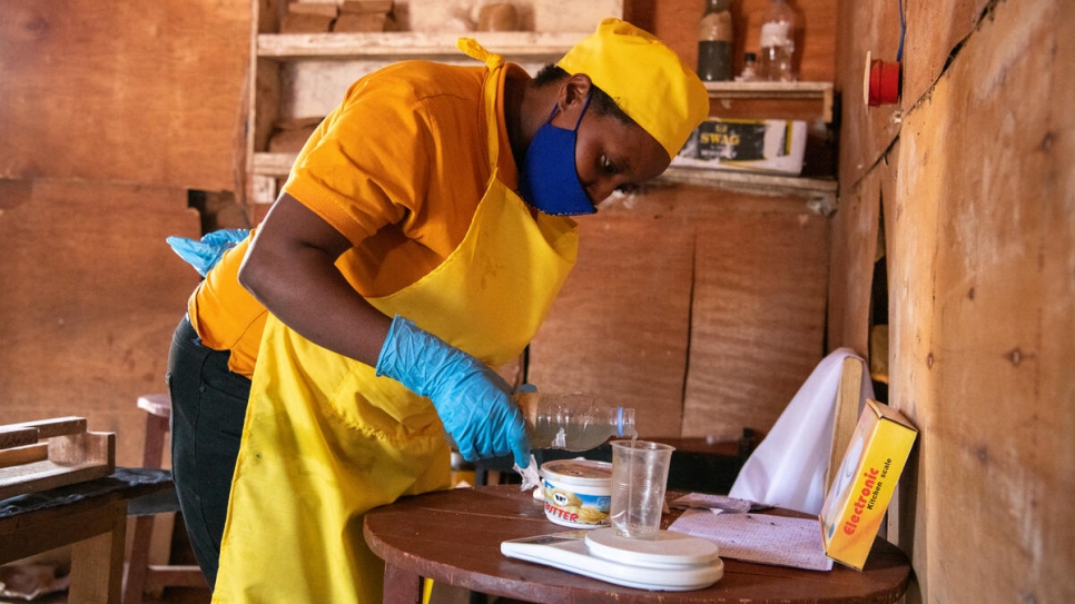 Aneilla Nizeyimana, de Burundi, pesa cuidadosamente ingredientes para hacer jabón en su tienda en el campamento de refugiados de Mahama, Ruanda.