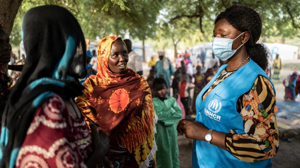 Remadji Ngarone, Oficial Asistente de Protección de ACNUR, habla con personas refugiadas camerunesas en el pueblo de Ngama-Kotoko, en Chad. 