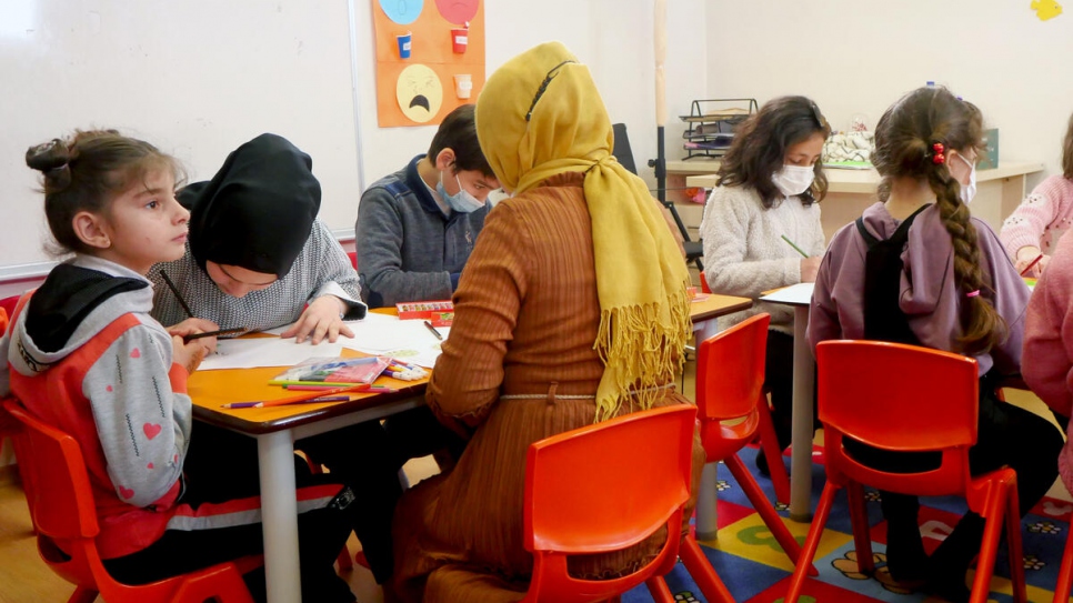 Niñas y niños sirios acompañados por una psicóloga capacitada durante una sesión de dibujo en Ankara, capital turca.