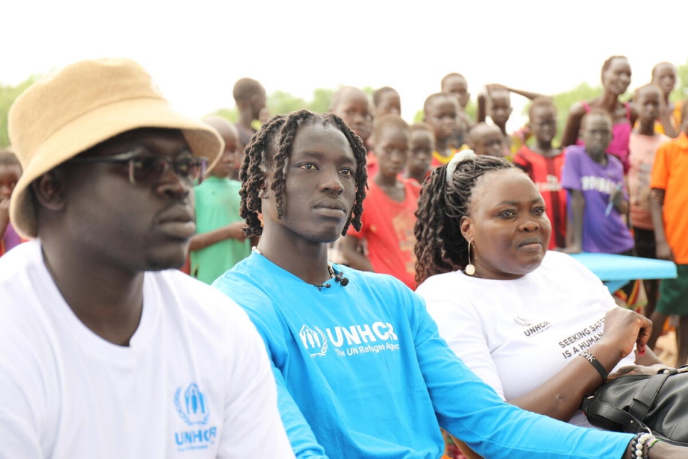 Wenyen Gabriel, colaborador de ACNUR, exrefugiado y jugador de Los Ángeles Lakers, con su madre Rebecca (a la derecha) y su hermano Komot (a la izquierda) en el campamento de desplazados internos de Mangalla, en Sudán del Sur.