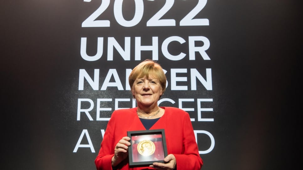 Angela Merkel pose avec la distinction Nansen lors de la cérémonie de remise. 