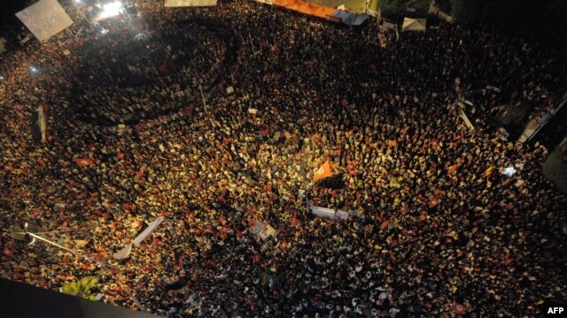 Tunisian people with flags chant slogans in front of the National Constituent Assembly on August 6 in Tunis. 