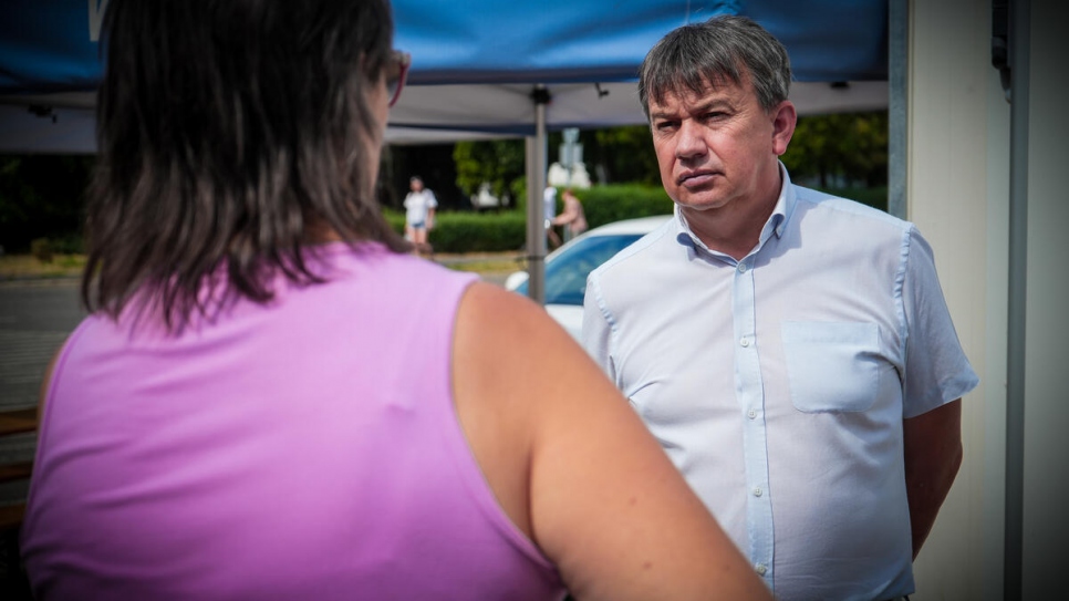 The mayor talks to a municipality colleague outside the town's train station. 