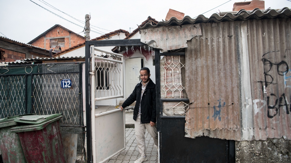 Valentin standing in front of the home he shares with his seven siblings.