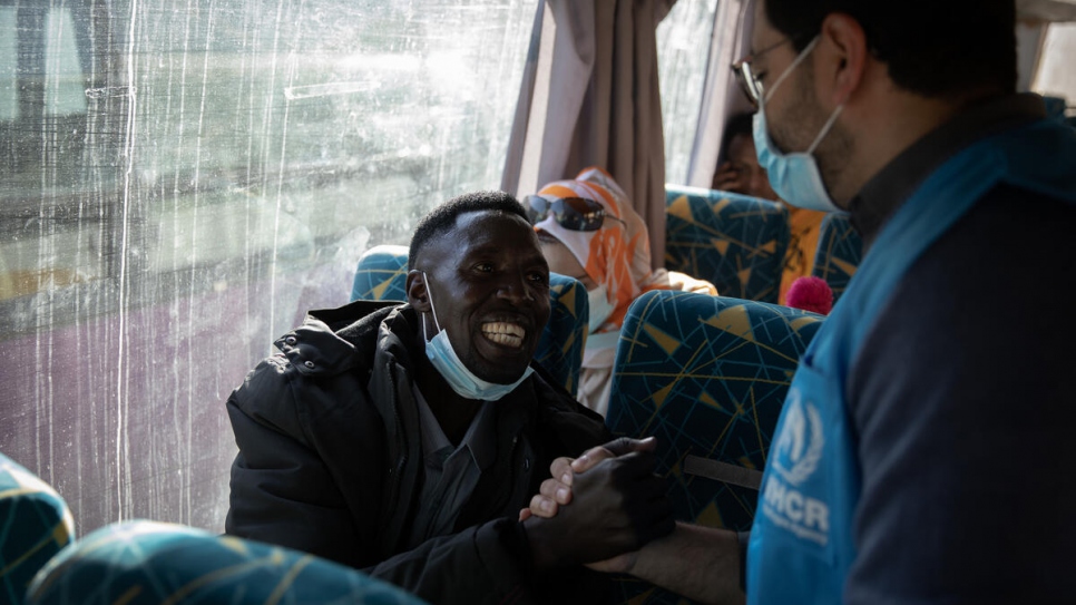 Osman, un demandeur d'asile soudanais, fait ses adieux à un membre du personnel du HCR alors qu'il se dirige vers l'aéroport de Tripoli.