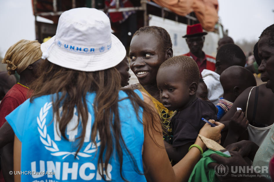 South Sudanese refugee Kiden Sam, 28, centre, carries her five-year-old Yukan Stephen as she waits to board a truck heading for the recently established Imvepi settlement, at the Imvepi Reception Centre, Arua District, Northern Region, Uganda.