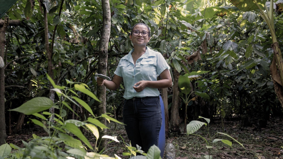 Dara Argüello makes the rounds on Vicenta's cacao plantation, tending to the trees and looking out for ripe pods.