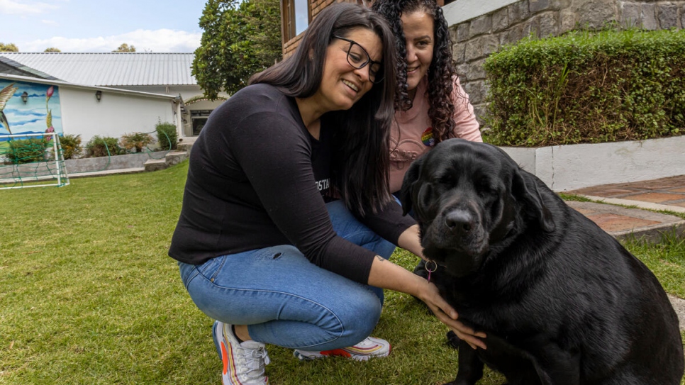 Zailet (left) and Yeraldine play with a dog at the Quito hotel where they both work.