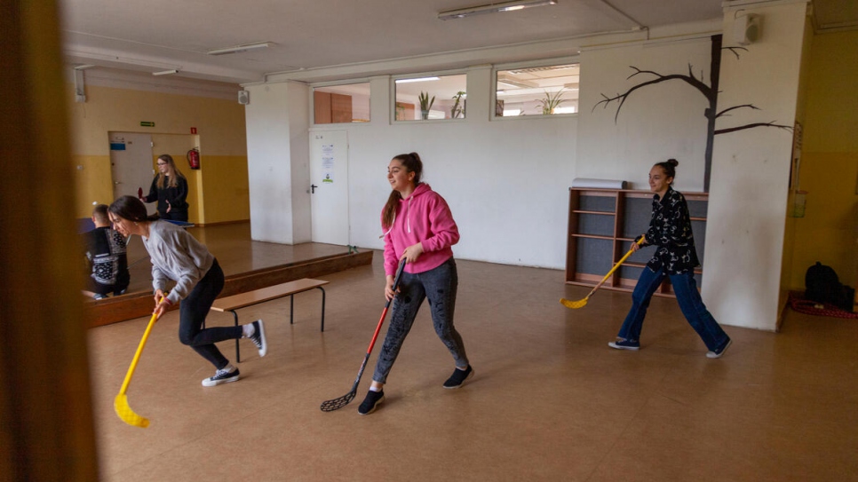 Sofia plays hockey with her classmates during a physical education lesson.