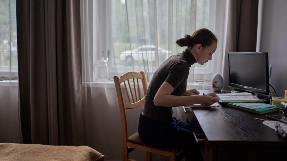 Daria studies at a desk in the family's bedroom where she joins online classes with her teachers and classmates from Ukraine.