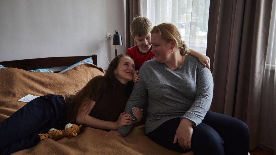 Daria with her mother Olga, 42, and younger brother Sergey, 7, in the bedroom of their accommodation.