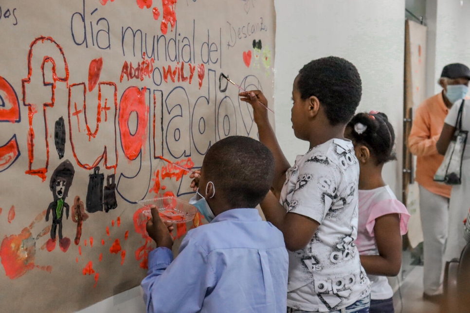 Children of Haitian Refugees paint mural during Dominican Republic's World Refugee Day Celebration.