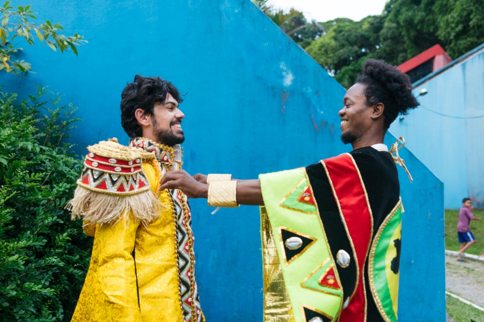 Yves Abdalá helps his fellow refugee, Syrian Adel Bakkour, put the finishing touches on his costume before the two headed to Rio's Carnival parade.