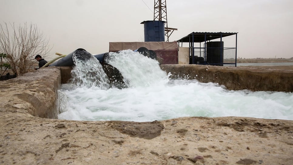 Water gushes down concrete channels following repairs to an irrigation station near Deir ez-zor.  