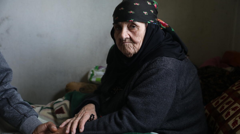 Amina holding her son Abdo's hand before going to her vaccination appointment.