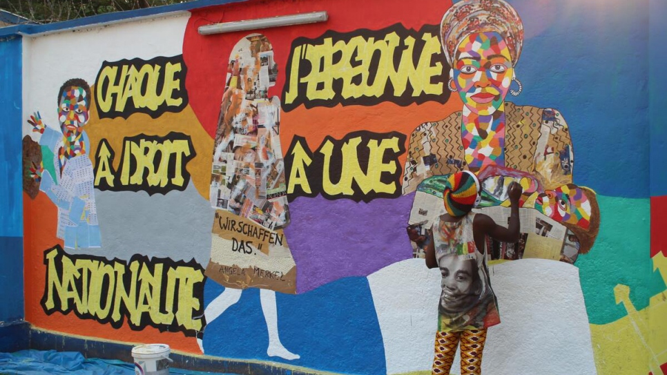 A refugee artist works on a mural to commemorate World Refugee Day in Kinshasa, the Democratic Republic of the Congo.