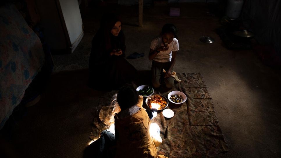 Majida and her daughters share a lunch of bread and vegetables.