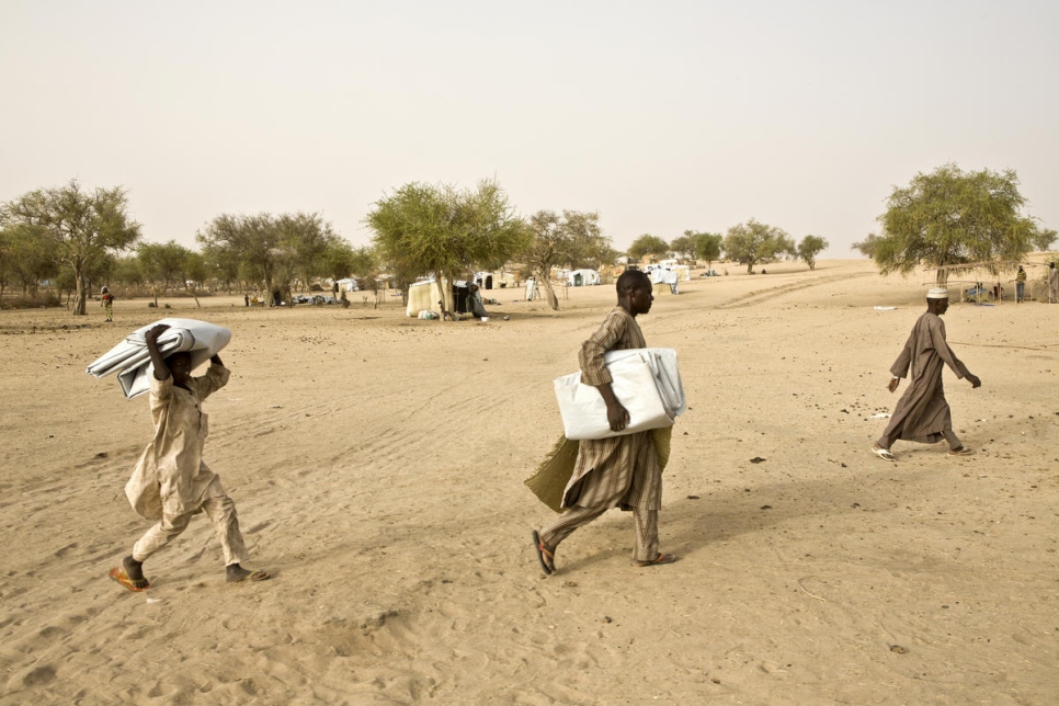 Des réfugiés nigérians portent des bâches en plastique pour recouvrir des abris dans le camp de réfugiés de Savam Forage à Diffa au Niger. Photo d'archives, mai 2016.