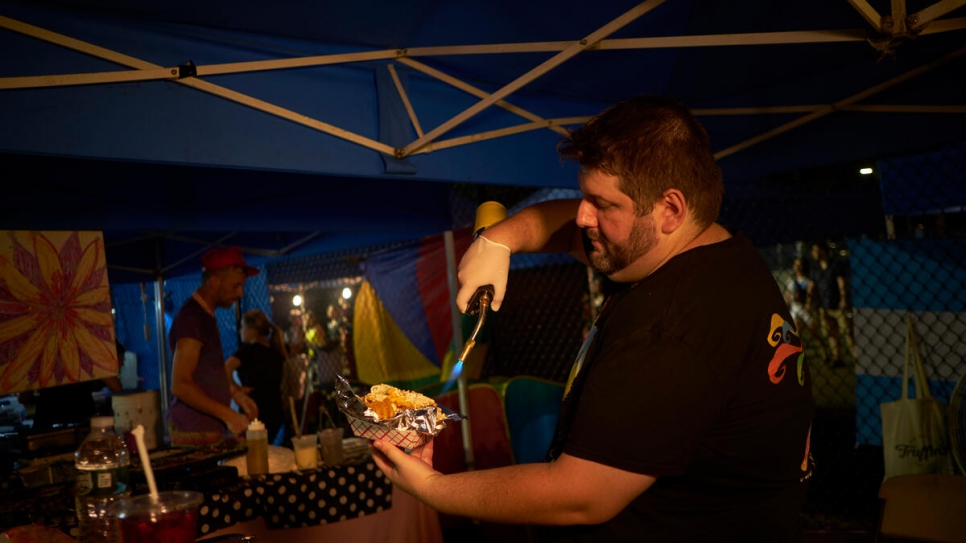 Sam Ilyayev from Taste of Ukraine serves up blintzes at the Queens Night Market. His father was a refugee from Uzbekistan while his wife is from Ukraine.