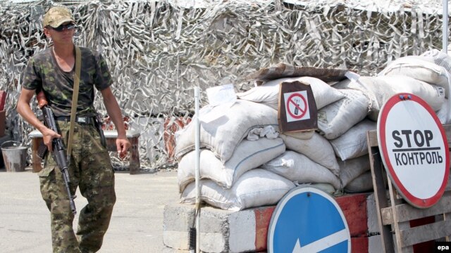 A pro-Russian separatist mans a checkpoint 25 kilometers from the rebel stronghold of Donetsk on July 23.