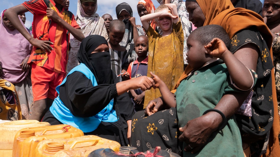 Women and children fill jerry cans with water at a site for internally displaced people in Dollow. 