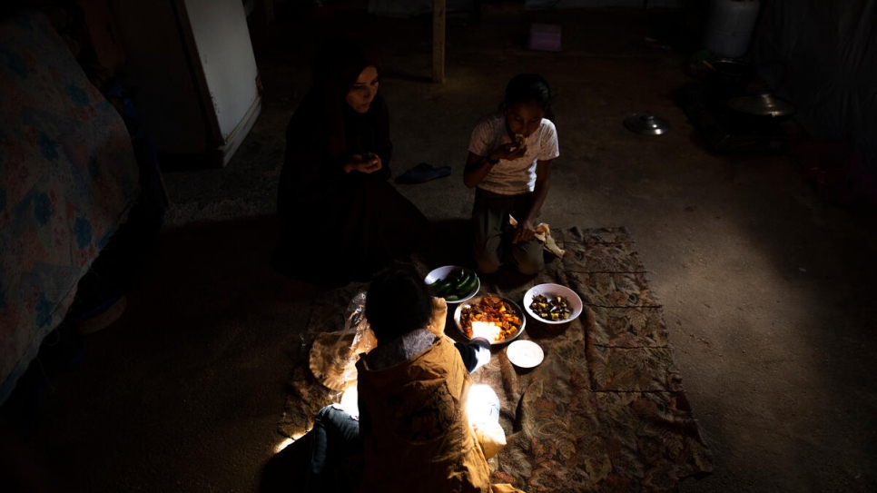 Majida et ses filles partagent un repas composé de pain et de légumes.