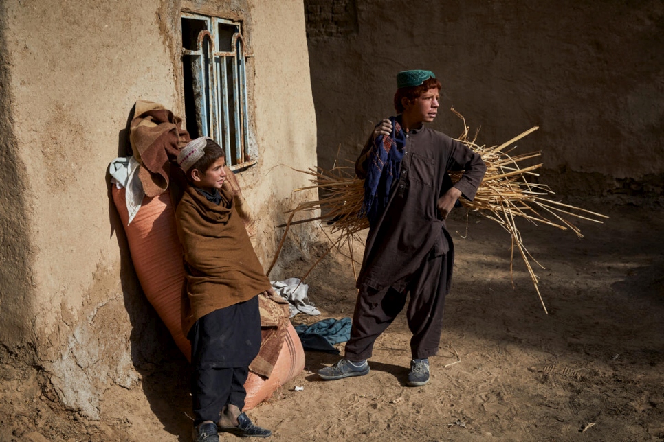 Adbul Wadood*, 13 ans (à droite), dans sa maison partiellement endommagée à Marja. Son père, Sayed Mohammad*, ainsi que sa mère et ses cinq frères et soeurs sont rentrés pour reconstruire leur maison après six ans de déplacement.  