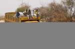 A truck rented by UNHCR to transport aid supplies and relocate refugees from the border to the refugee camps attempts to rescue an NGO car stuck in the flooded river bed between Bahai and Tine. (July 18, 2004)