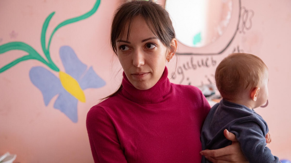 Oleksandra holds 7-month-old daughter Polina in their room at the Mukachevo State University dormitory.