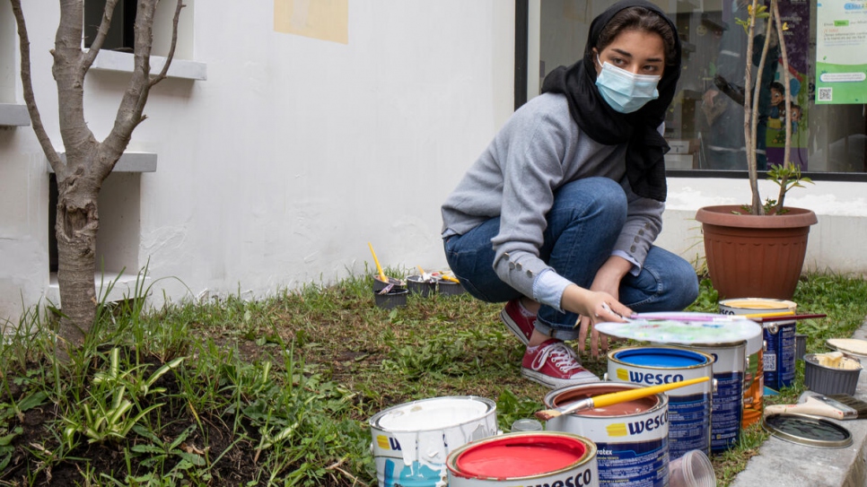 Zohra se prépare à réaliser une fresque sur les murs du Centre pour l'égalité et la justice de Quito, où les habitants et les personnes déplacées reçoivent un soutien juridique. 