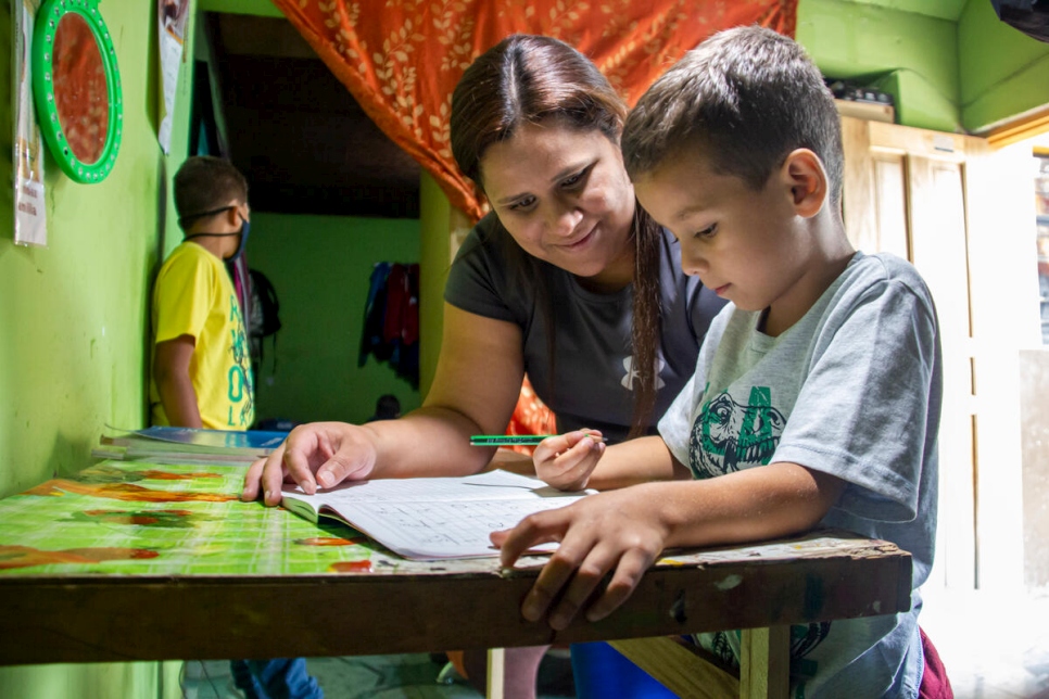 María José Mercado helps one of her sons with his homework. Getting regular status will help her children complete their education in Ecuador.